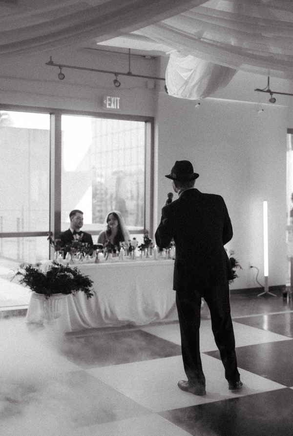 Black and white picture of lead singer of our Frank Sinatra cover band singing to newlyweds | Altus Entertainment